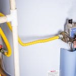 Handyman attaches a gasline to a water heater